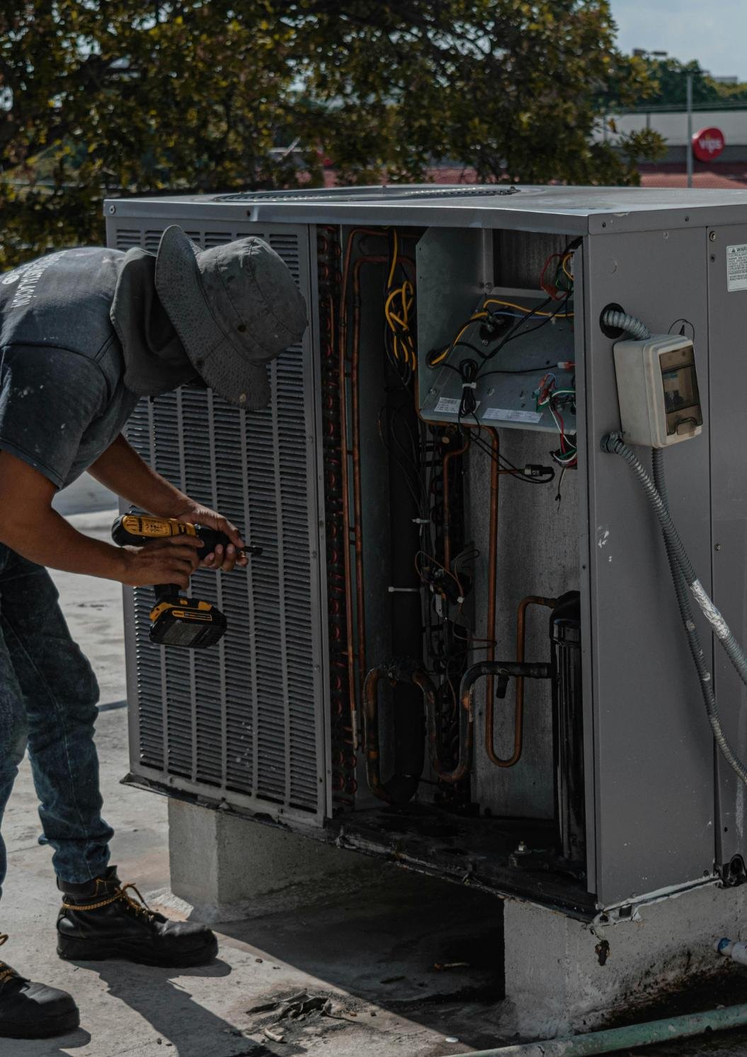 Técnico de Refri Express reparando una unidad de aire acondicionado comercial en azotea